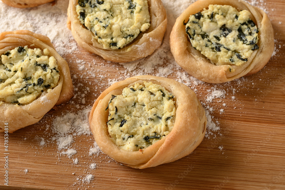 open sfiha filled with ricotta cheese and spinach on a wood open sfiha filled with ricotta cheese and spinach on a wood