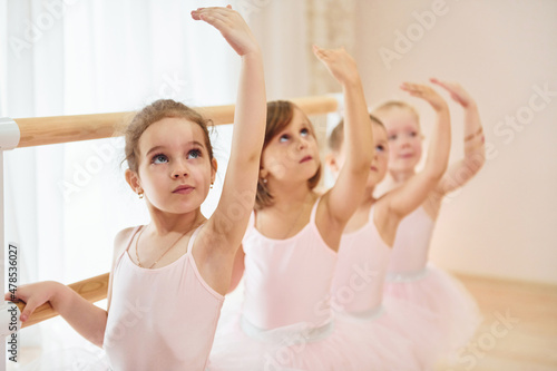 Little ballerinas preparing for performance by practicing dance moves