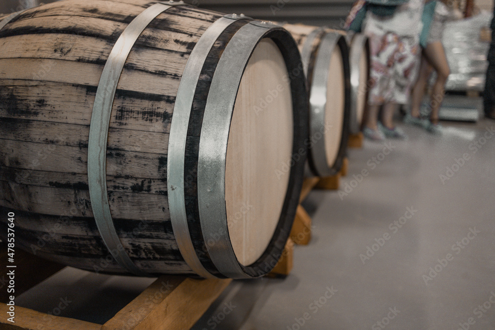 Old oak wood barrels with beer in the underground cellar Old oak wood barrels with beer in the underground cellar