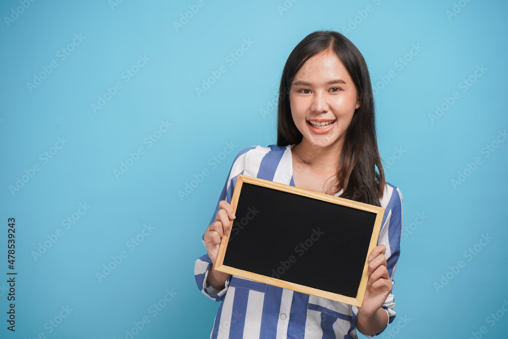 Pretty young woman holding and show empty blank black board for advertising banner and copy space on colorful background Pretty young woman holding and show empty blank black board for advertising banner and copy space on colorful background