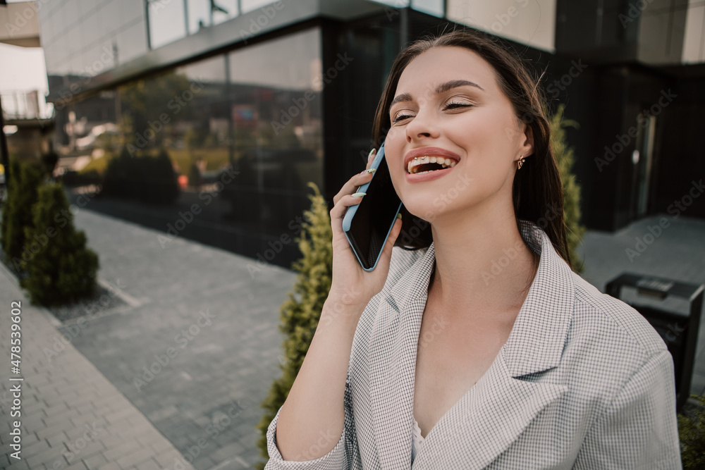 Small business owner office worker smiling happy woman standing outside building speak on phone with client. Female successful executive girl wait colleague meeting. Copy space. Small business owner office worker smiling happy woman standing outside building speak on phone with client. Female successful executive girl wait colleague meeting. Copy space.