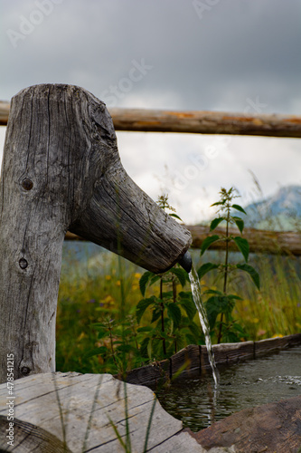 Dettaglio di fontanella in legno in alta montagna (Dolomiti, Italia) photo