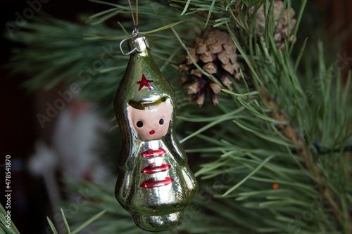 Vintage old glass Christmas tree toy 1970s Soviet period dolls - a red army boy on pine branches close-up.