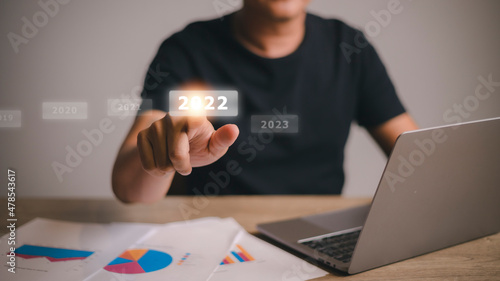 welcome year 2022 New year 2021 change to 2022 concept, businessman hand touching on 2022 virtual screen.