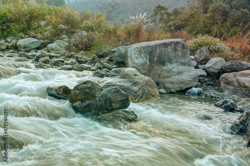 Beautiful Reshi River water flowing through stones and rocks at dawn, Sikkim, India. Reshi is one of the most famous rivers of Sikkim flowing through the state and serving water to many local people. photo