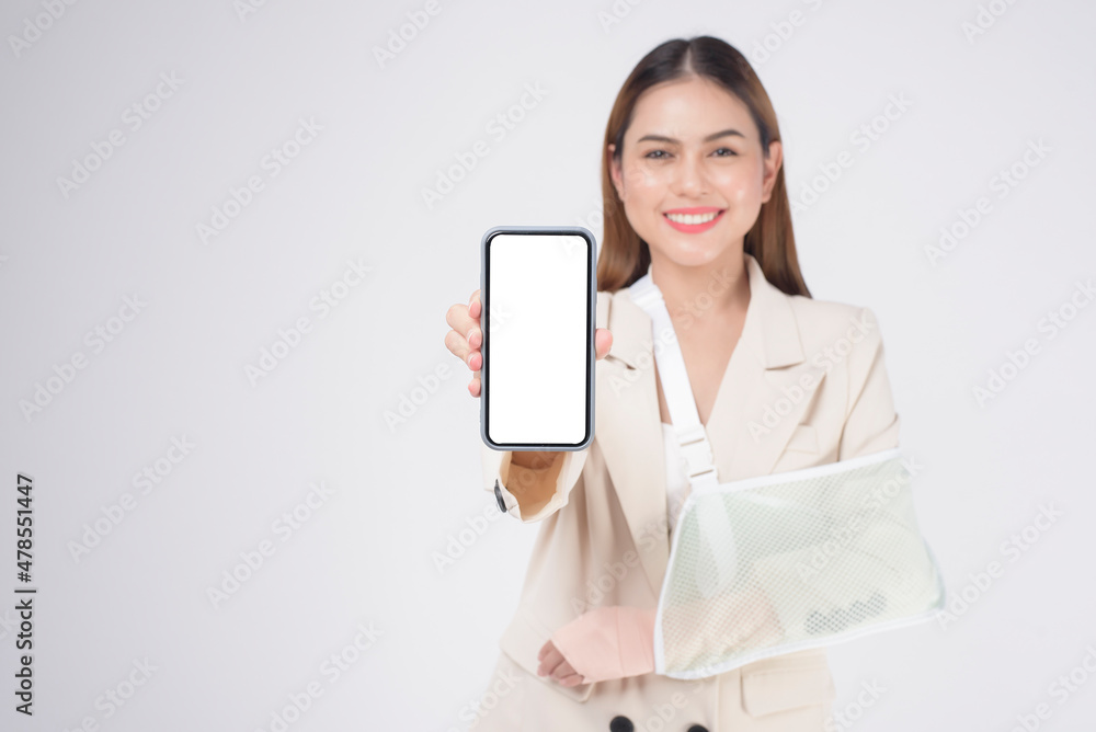 Portrait of young woman with an injured arm in a sling over white background in studio.. Portrait of young woman with an injured arm in a sling over white background in studio..