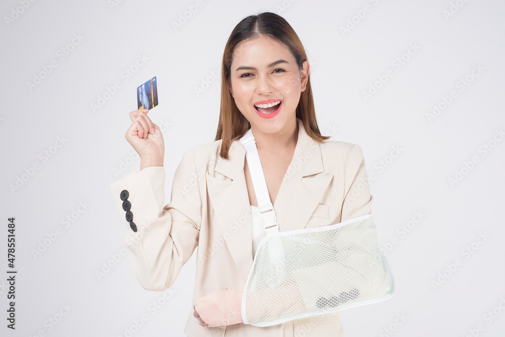 Portrait of young woman with an injured arm in a sling over white background in studio.. Portrait of young woman with an injured arm in a sling over white background in studio..