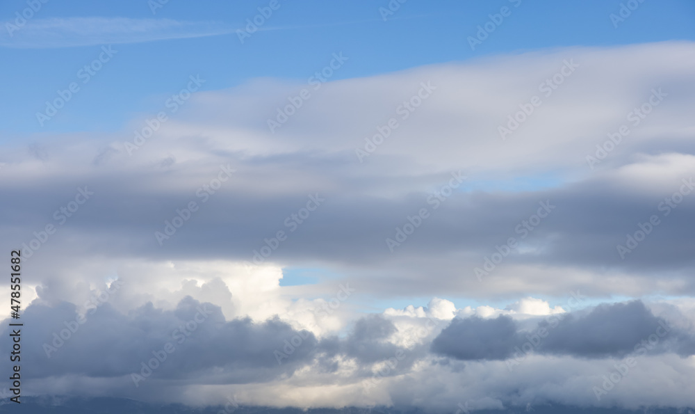 View of Cloudscape during a cloudy blue sky sunny day. Taken over the mountain at the West Coast of British Columbia, Canada.