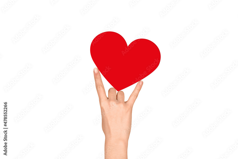 Red heart sandwiched between the fingers on a white background. Valentine's Day Red heart sandwiched between the fingers on a white background. Valentine's Day