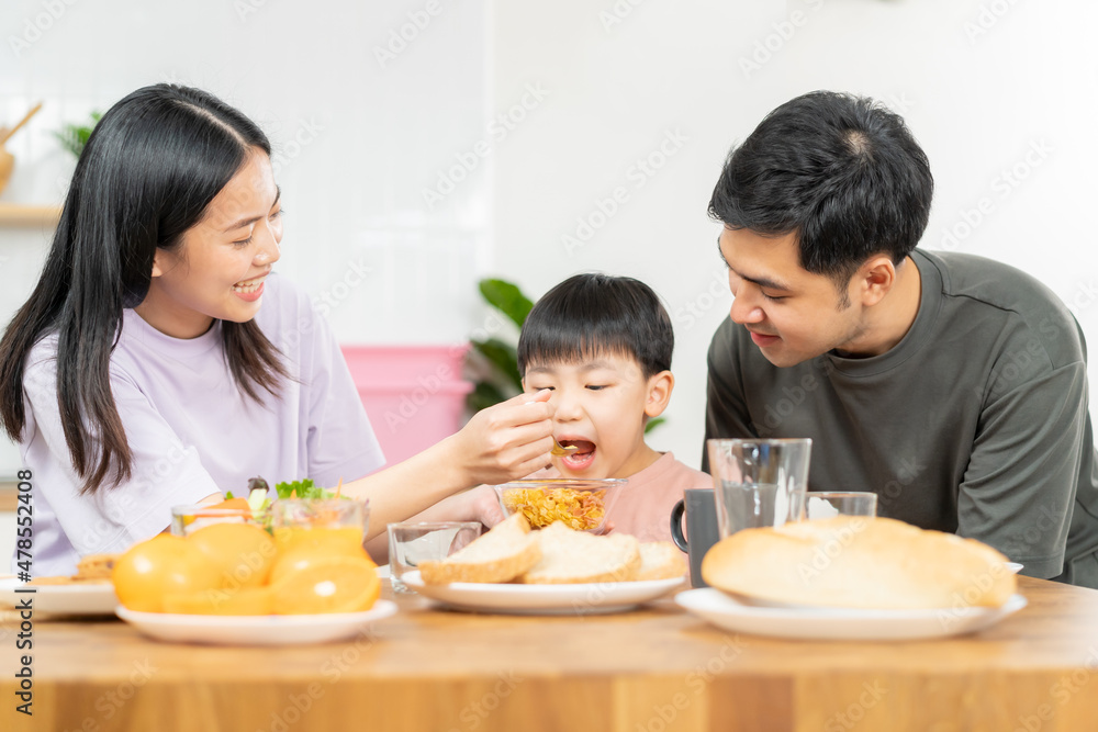 Happy refreshment family breakfast in morning, asian young parent father, mother and little cute boy, child having meal in kitchen eating together at home. Cheerful, enjoy cooking people. Happy refreshment family breakfast in morning, asian young parent father, mother and little cute boy, child having meal in kitchen eating together at home. Cheerful, enjoy cooking people.