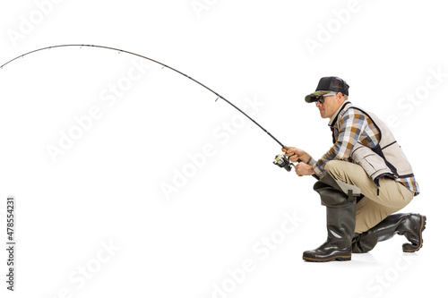 Portrait of young man, professional fisherman with fishing rod, spinning and equipment fishing isolated over white studio background