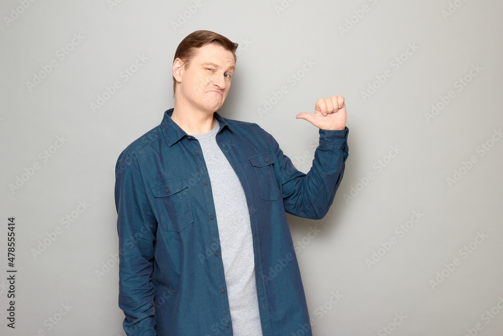 Portrait of funny proud mature man pointing with thumb at himself Portrait of funny proud mature man pointing with thumb at himself