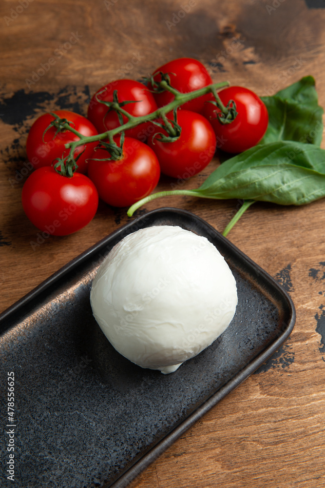 A ball of mozzarella cheese on a wooden table. A ball of mozzarella cheese on a wooden table.