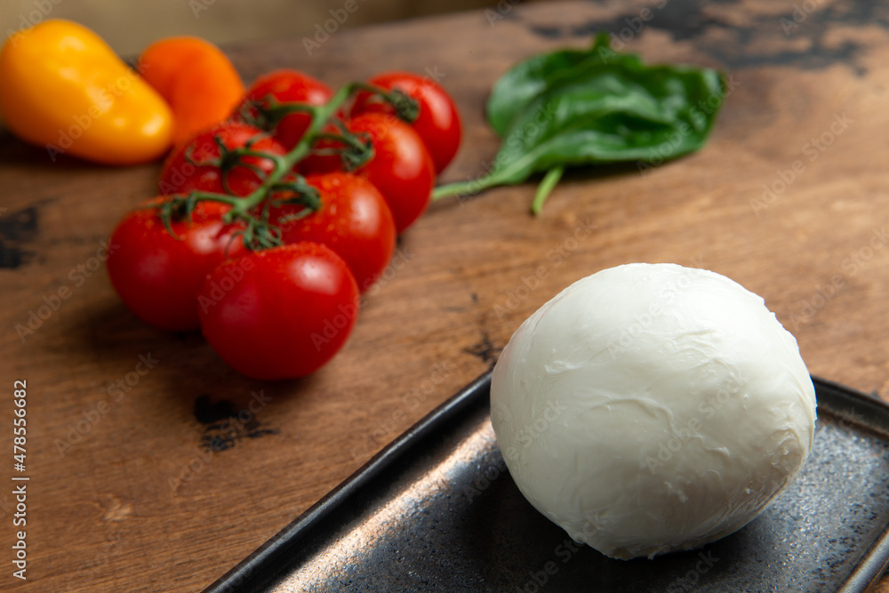 A ball of mozzarella cheese on a wooden table. A ball of mozzarella cheese on a wooden table.