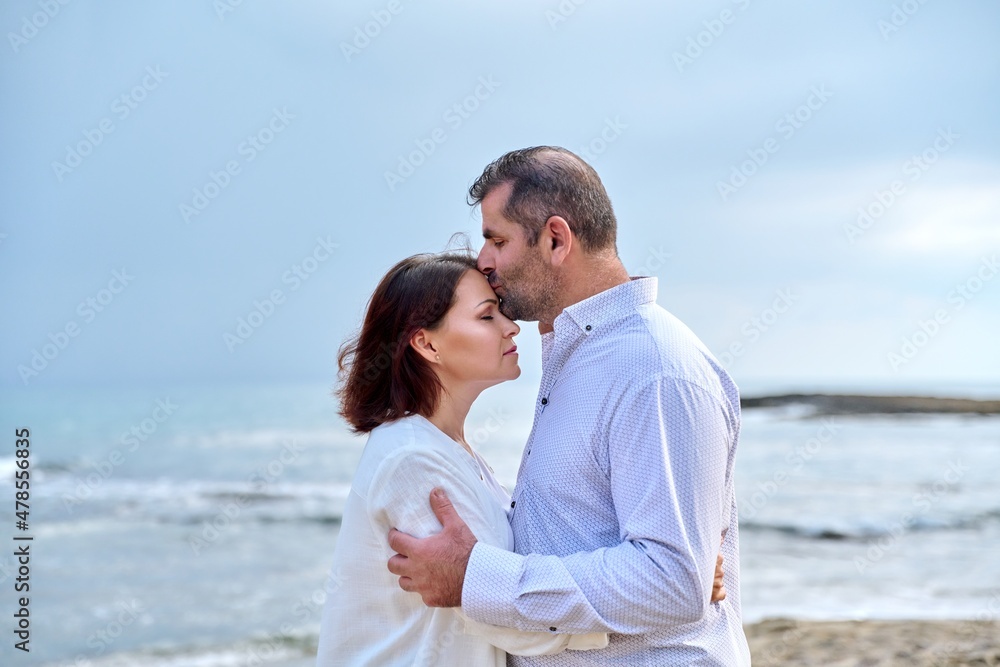 Mature happy loving couple kissing on the sea beach. Mature happy loving couple kissing on the sea beach.