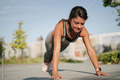 Fit athlete woman in sportswear outdoors. Young woman training in the park