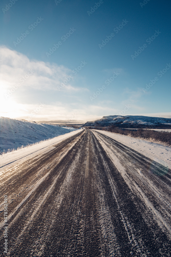 The road to nowhere. Wildlife in the Finnmark region of northern Norway on the border with Finland. Rough, inhospitable nature in winter with sunrise and blue skies. Exploring the polar region The road to nowhere. Wildlife in the Finnmark region of northern Norway on the border with Finland. Rough, inhospitable nature in winter with sunrise and blue skies. Exploring the polar region
