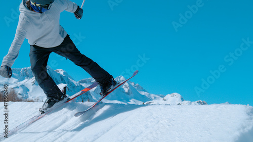 CLOSE UP: Freestyle skier rides backward and lines up to jump off a kicker.