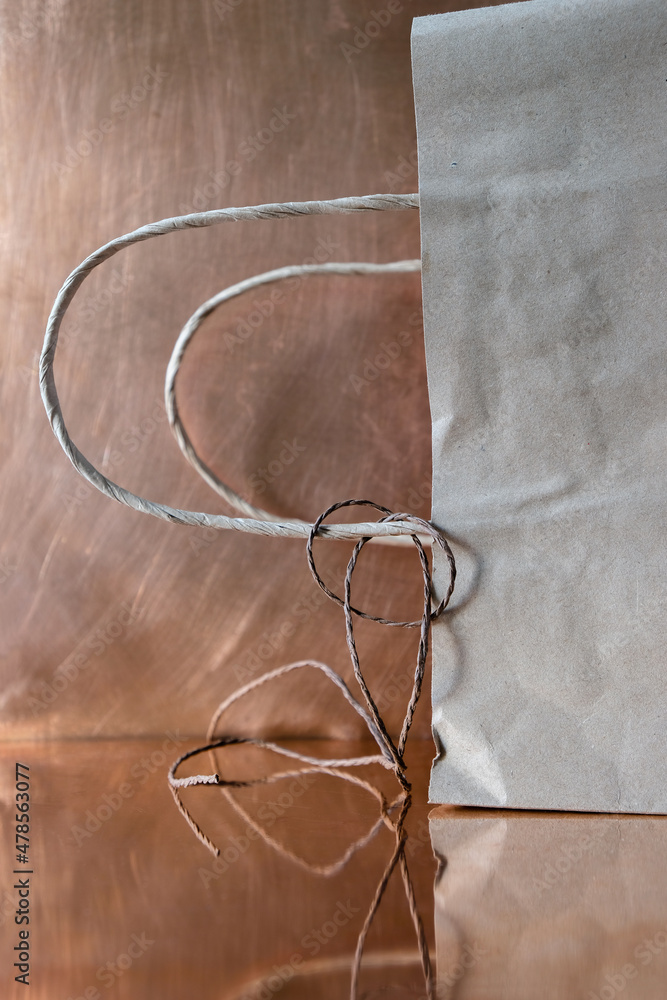 Natural paper bag on a copper surface. Mockup. Plastic-free concept. Vertical image. Natural paper bag on a copper surface. Mockup. Plastic-free concept. Vertical image.