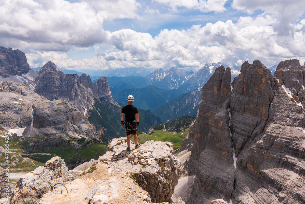 Climbers silhouette standing on a cliff in Dolomites. Tofana di Mezzo, Punta Anna, Italy. Man Celebrate success on top of the mountain Hiker standing on rocky ridge and enjoying the view in Dolomites