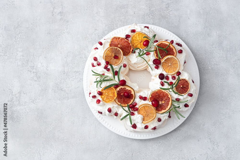 Meringues pavlova cake wreath with whipped cream, pomegranate and orange Meringues pavlova cake wreath with whipped cream, pomegranate and orange