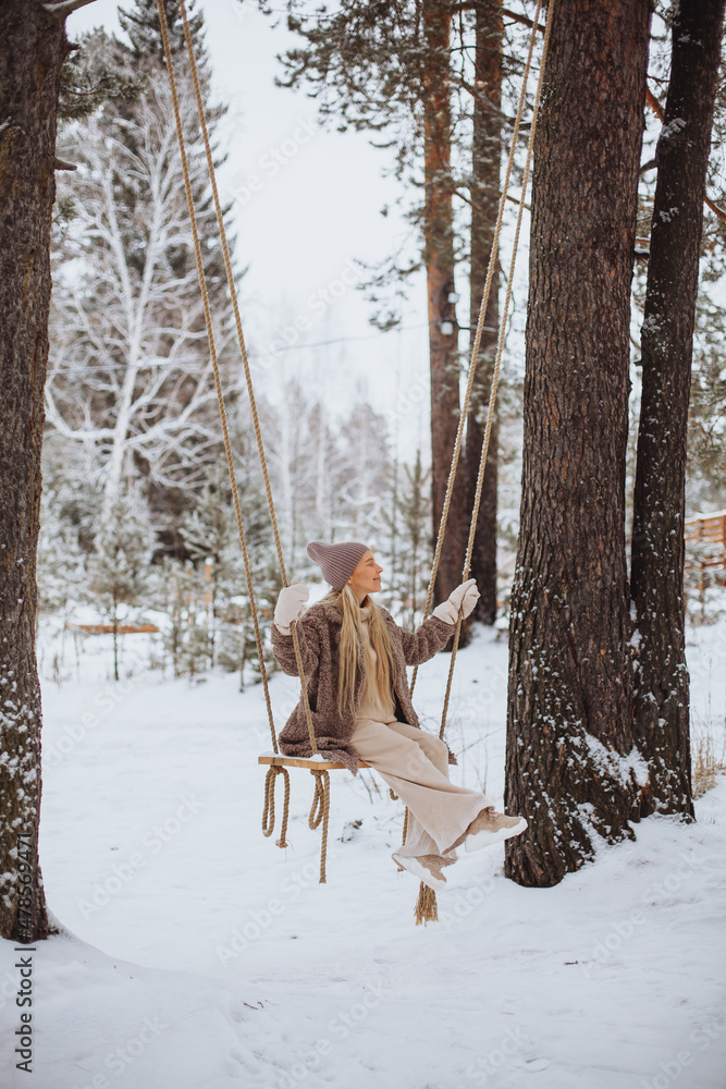 Young girl swinging on a swing in winter