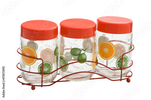 Três copos de vidro decorado e com tampa vermelha com suporte de ferro em fundo branco (ID: 478570415)