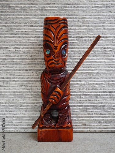 Hand-carved figure TEKO TEKO from New Zealand on a gray background. photo