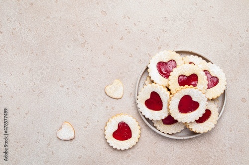 Linzer cookies in shape of heart with jam on light background. Mother's day, Women's day, Valentine's day. Homemade present. Copy space, top view.