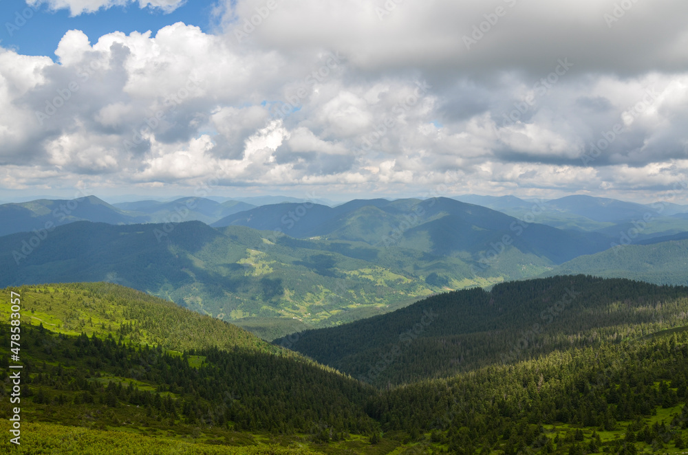 Beautiful carpathian nature scenery with mountains corered forest and village in the valley. Summer day in the Carpathians, Ukraine