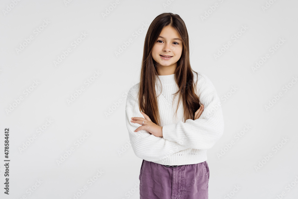 Portrait of young woman with confident smile, relaxed professional pose cross arms on chest, standing against white background Portrait of young woman with confident smile, relaxed professional pose cross arms on chest, standing against white background