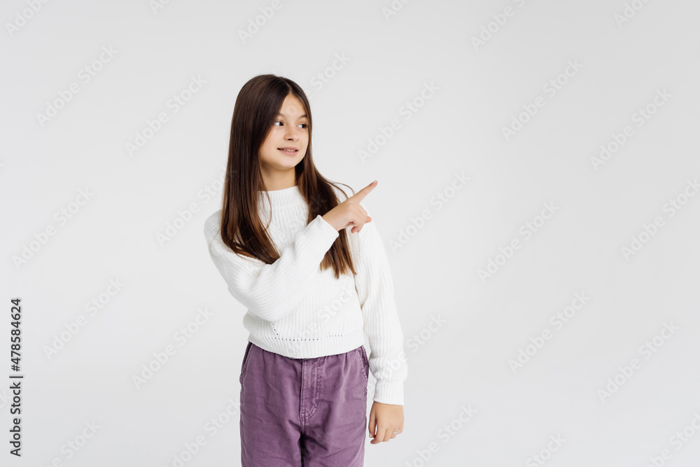 Smiling girl pointing fingers away at copy space over white background Smiling girl pointing fingers away at copy space over white background