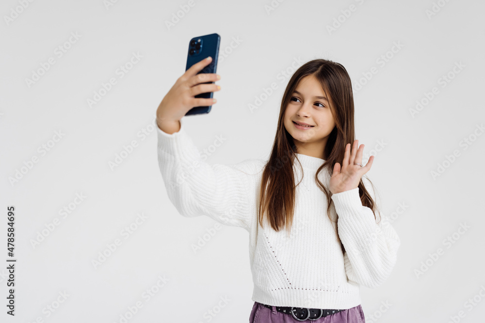 Teen girl doing a video call on a white background Teen girl doing a video call on a white background