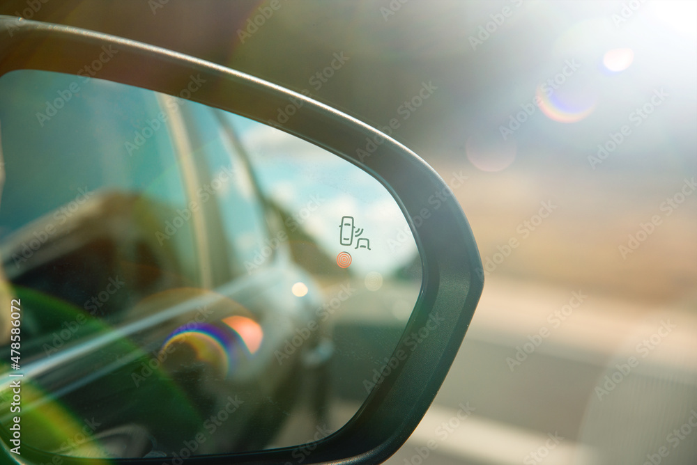 A blind spot monitoring sensor on the side mirror of a modern car A blind spot monitoring sensor on the side mirror of a modern car