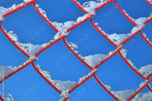 snow-covered red grid on a blue sky background