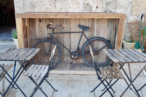 Vintage bike as cool decoration in outdoor seating area of restaurant in Marzamemi, Sicily, Italy.