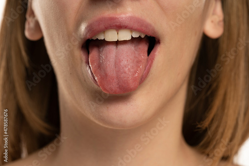 Cropped image of young woman showing tongue