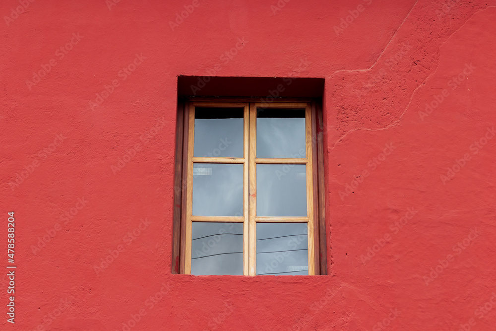 colonial window  on a red wall in antigua guatemala
