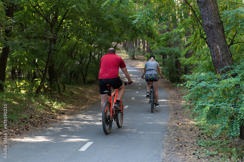 Man and woman ride bicycles in the forest