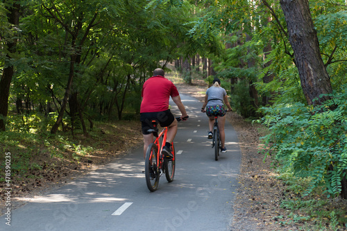 Man and woman ride bicycles in the forest