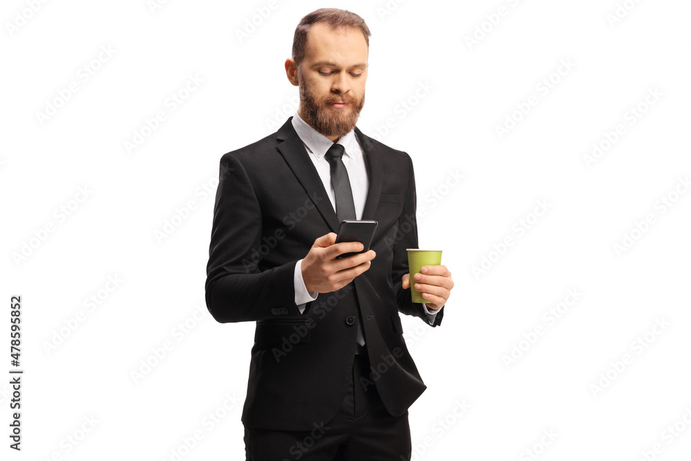 Young professional man holding a takeaway coffee cup and typing on a smartphone Young professional man holding a takeaway coffee cup and typing on a smartphone