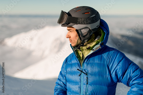 portrait of male skier in jacket and helmet on his head