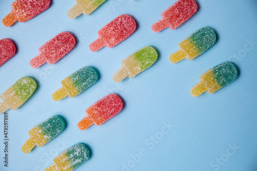 Sugary gummy popsicle candy pattern on blue