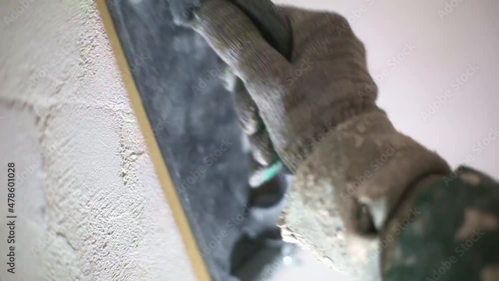 Sanding of walls with sandpaper after treatment with dry building mixes