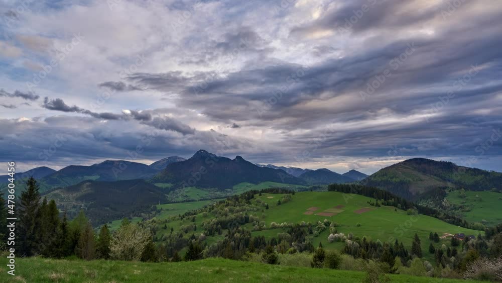 Green spring blooming landscape after rain. Grassy pastures in a hilly landscape. Colorful clouds Green spring blooming landscape after rain. Grassy pastures in a hilly landscape. Colorful clouds