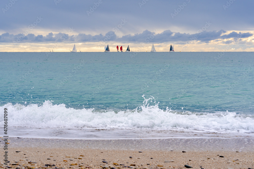 la mer, en hiver  avec des voiliers au loin sur l'horizon