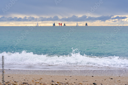 la mer, en hiver avec des voiliers au loin sur l'horizon