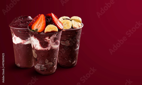 set of many Brazilian frozen açai berry ice cream bowls with diferent ingredients on a purple summer background. top view and front view for menu.