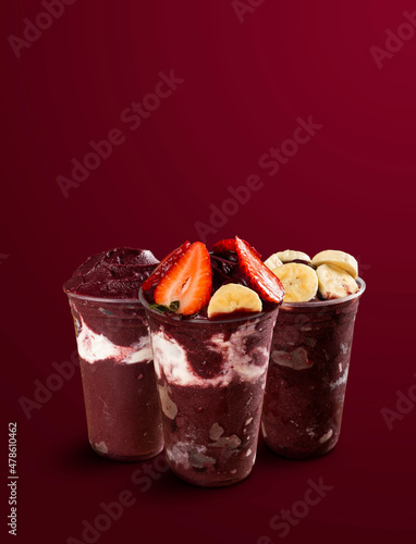 set of many Brazilian frozen açai berry ice cream bowls with diferent ingredients on a purple summer background. top view and front view for menu