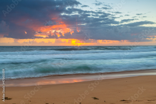 Sunrise at the seaside with waves and clouds